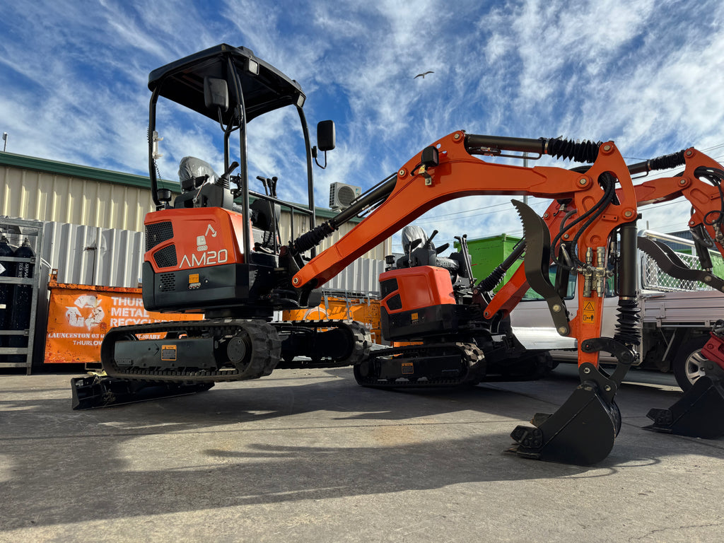 2.0 orange mini excavator with 'AM20' model on a construction site.